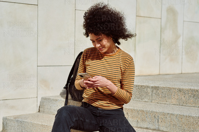 Attractive girl sending a text message outdoors