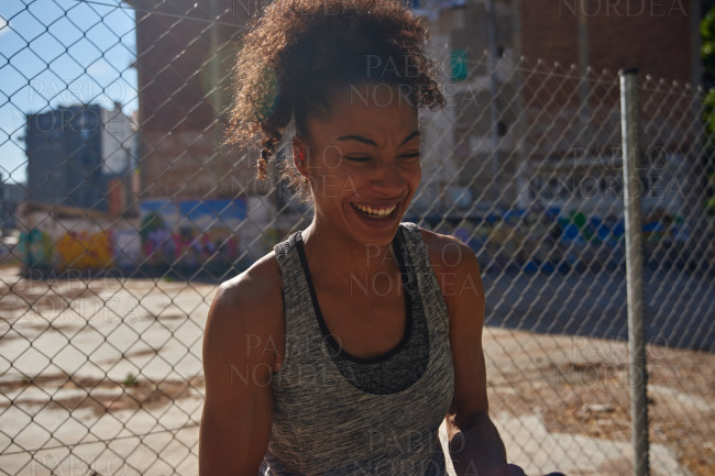 Cheerful young woman laughing in gym clothes