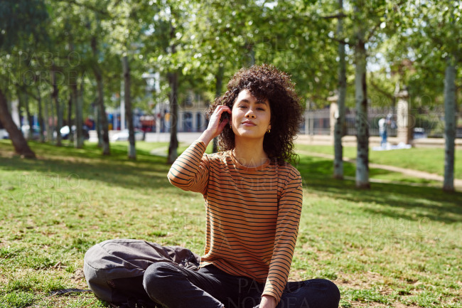 Cute young woman looking at camera in a park