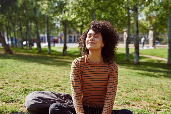 Cute young woman sitting with her eyes closed