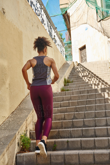 Fit young woman jogging on the stairs stock photo