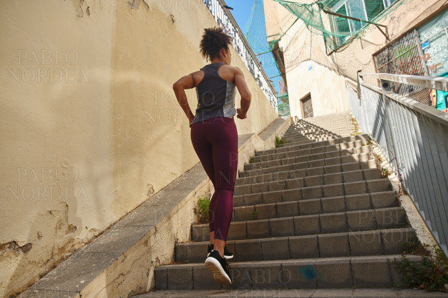 Fit young woman jogging up the stairs