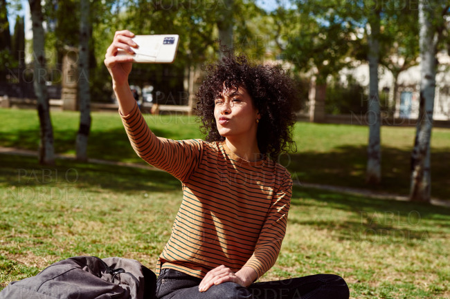 Pouting young woman taking a selfie in a park