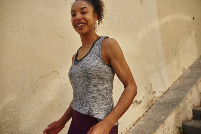 Smiling young woman jogging down the stairs