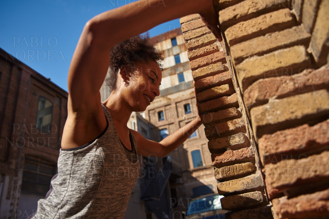 Smiling young woman working out in the city
