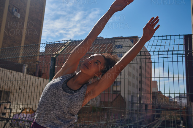 Sporty young woman doing stretch exercises alone