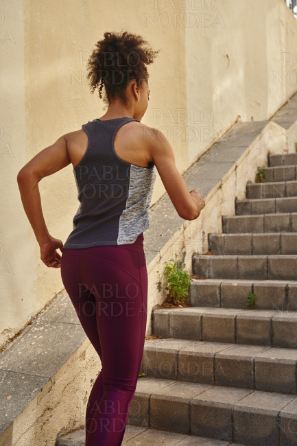 Sporty young woman jogging on the stairs