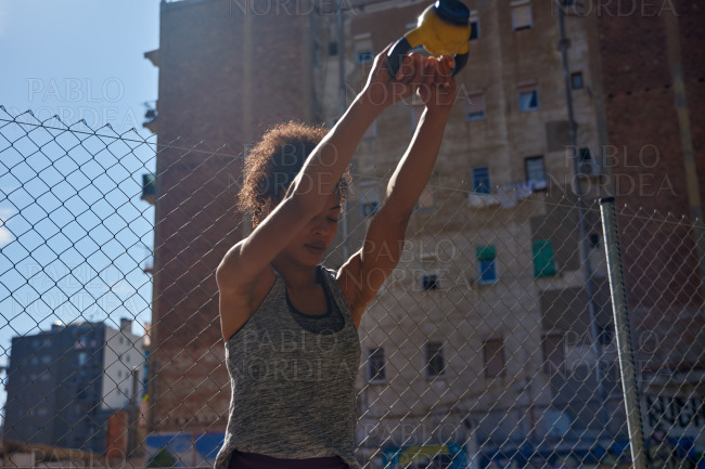 Young ethnic woman working out with a dumbbell