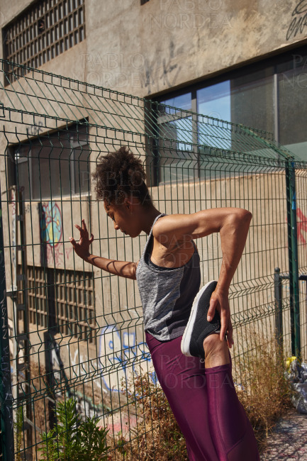 Young woman doing stretch exercises outdoors