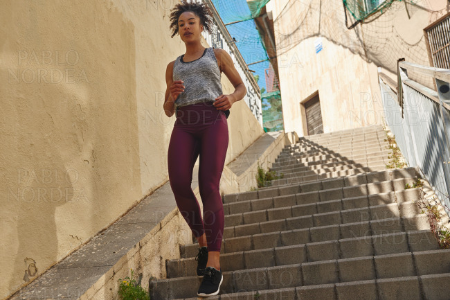 Young woman jogging down the stairs in the morning