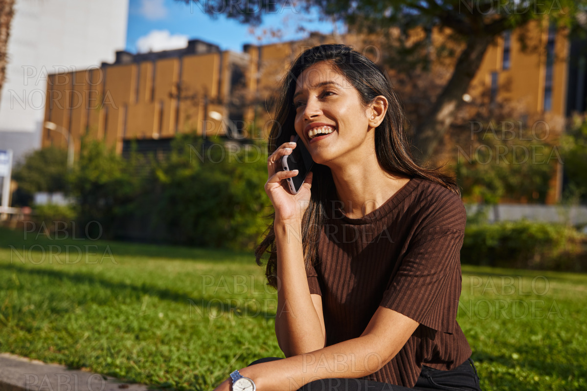 Laughing young businesswoman talking by phone stock photo