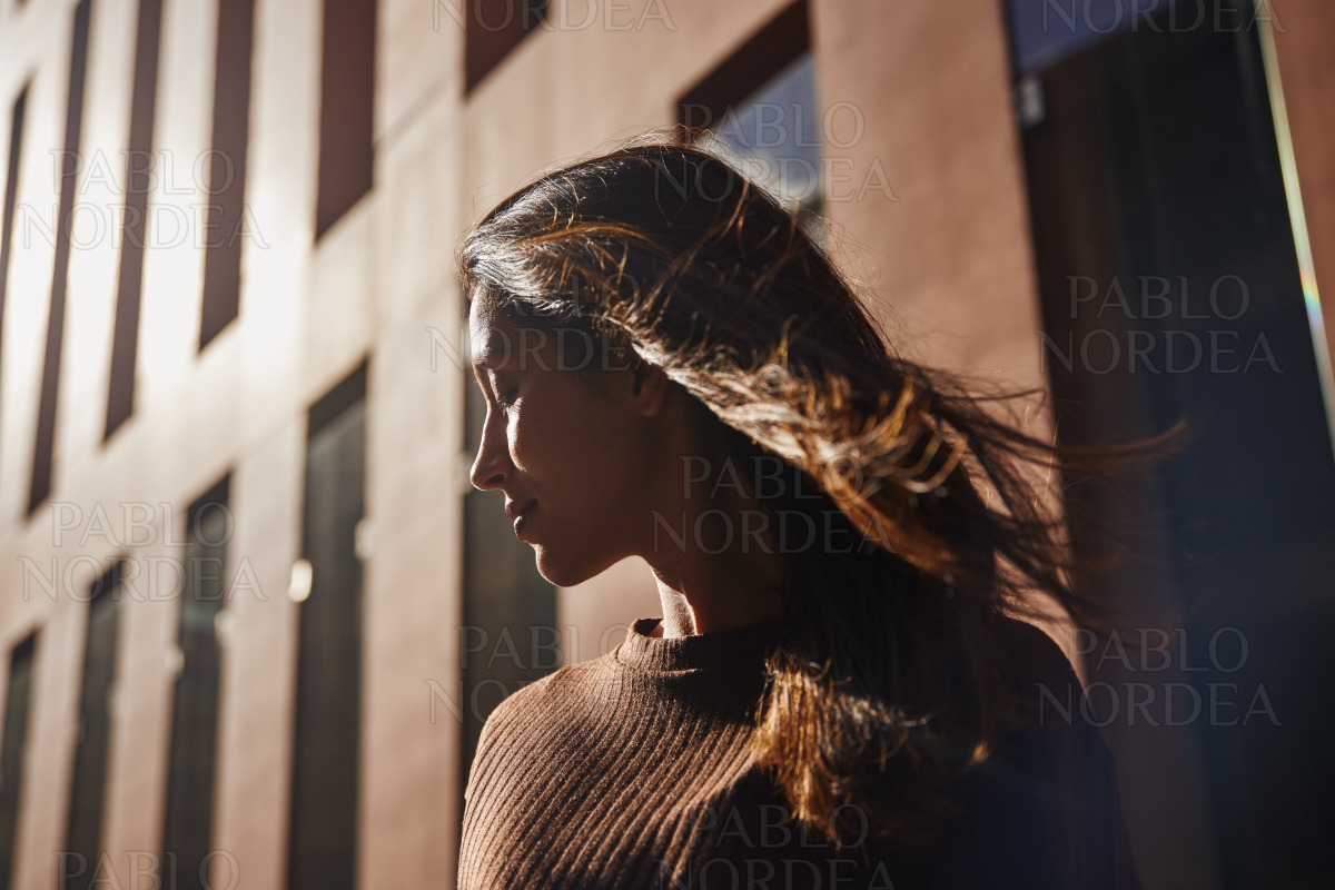 Young beautiful woman with eyes closed on street stock photo