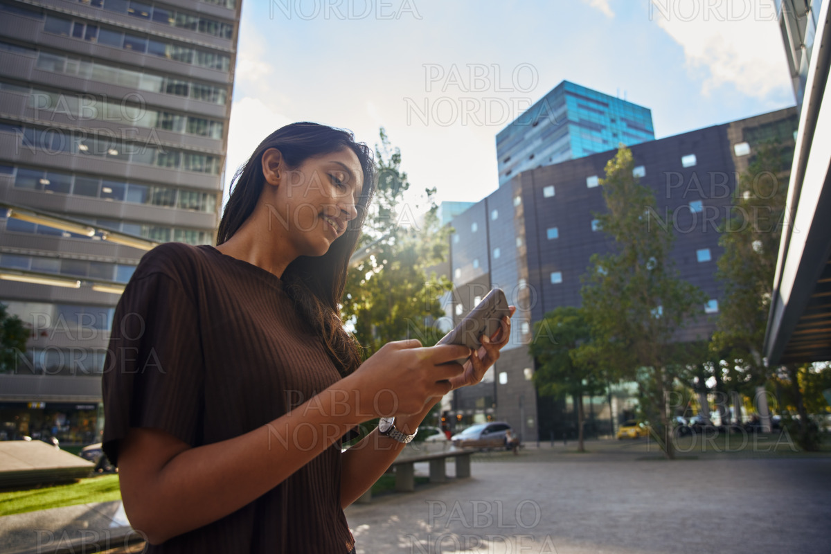 Young businesswoman using mobile phone in city stock photo
