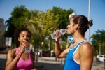Fit young couple drinking water outdoors