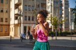 Happy young sportswoman laughing in the city