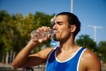 Sporty young man drinking water from a bottle
