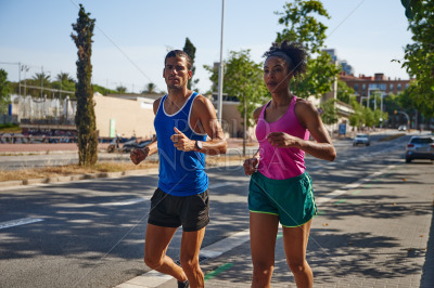 Active young couple jogging together in the city