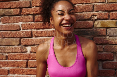 Athletic young woman laughing cheerfully outdoors