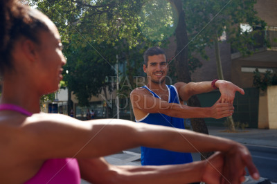 Cheerful young couple doing stretch exercises