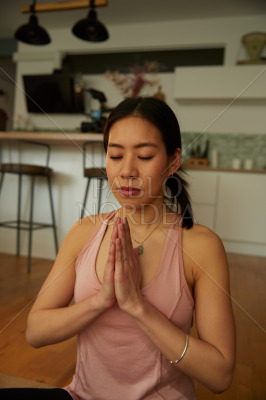 Female sportsperson praying while practicing yoga