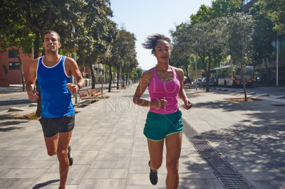 Fit ethnic couple jogging together outdoors