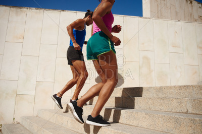 Fit young couple running up a staircase outdoors