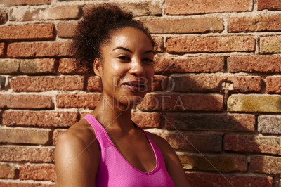 Fit young woman smiling at the camera outdoors