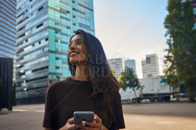 Happy cute businesswoman holding mobile phone
