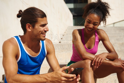 Happy young couple laughing together outdoors