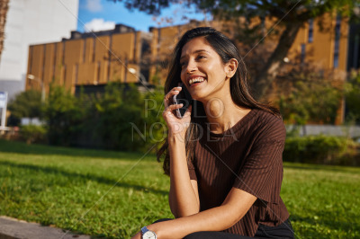 Laughing young businesswoman talking by phone