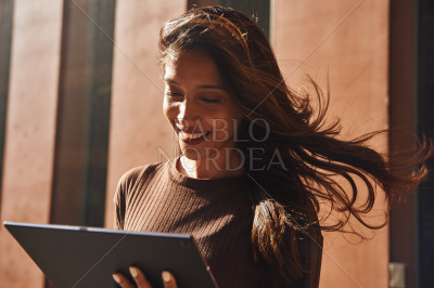 Smiling businesswoman with tablet on street