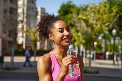 Smiling young woman holding a bottle of water