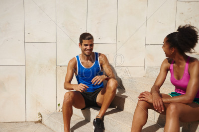 Sporty young couple having a chat outdoors