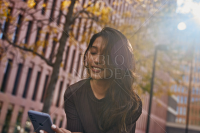 Young beautiful woman looking at mobile phone