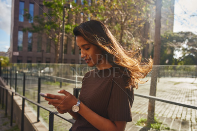 Young businesswoman leaning against railing in sun