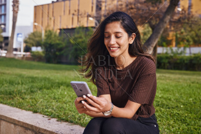 Young businesswoman sitting and text messaging