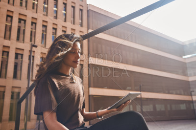 Young businesswoman sitting and using tablet