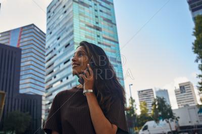 Young businesswoman standing and talking by phone