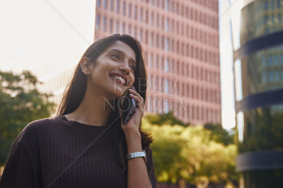 Young businesswoman talking on phone happily