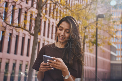 Young happy businesswoman enjoying mobile phone