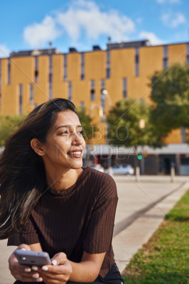 Young smiling businesswoman sitting in park