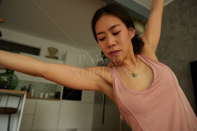 Young woman exercising yoga in apartment
