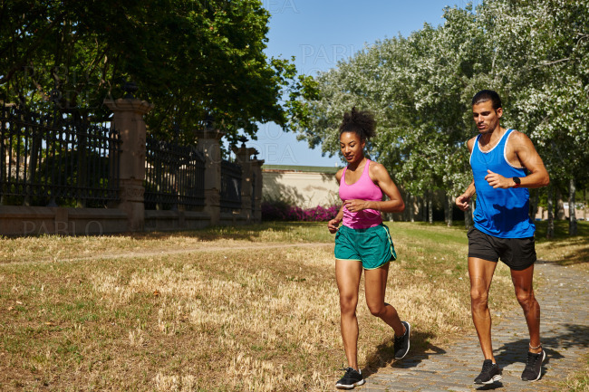 Active young couple running together outdoors