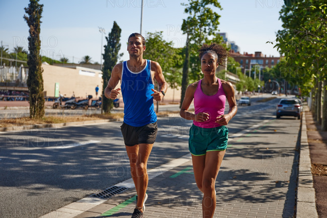 Athletic couple jogging together in the city