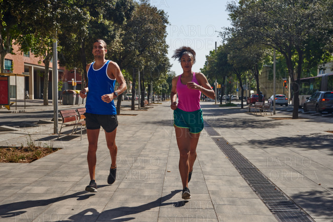 Dedicated young couple jogging together outdoors