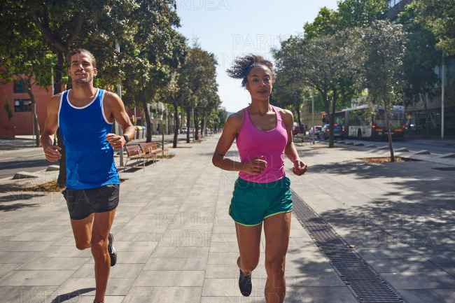 Fit ethnic couple jogging together outdoors