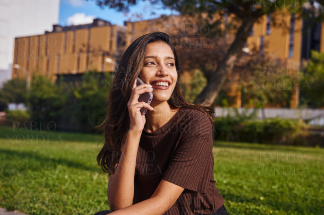 Happy businesswoman talking by phone in park