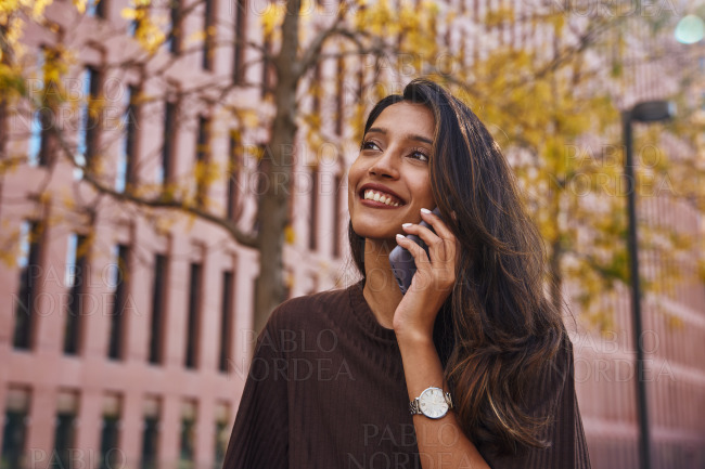 Happy businesswoman talking on phone on street