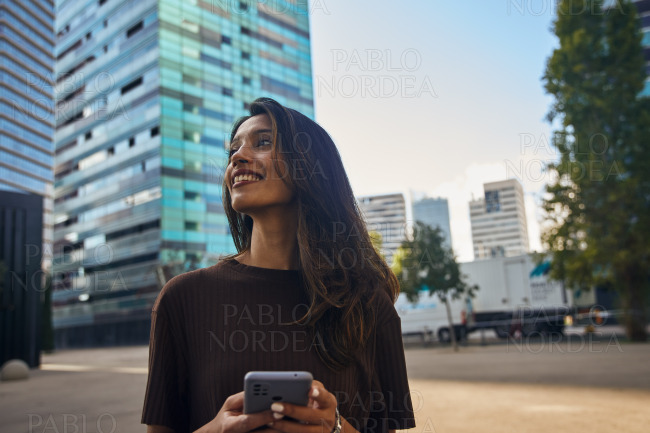 Happy cute businesswoman holding mobile phone