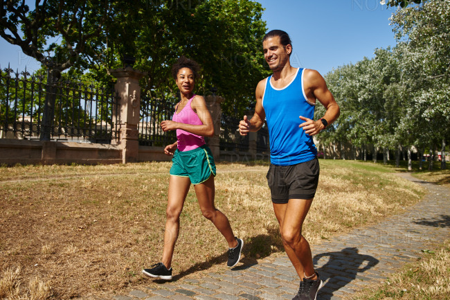 Happy young couple jogging together outdoors